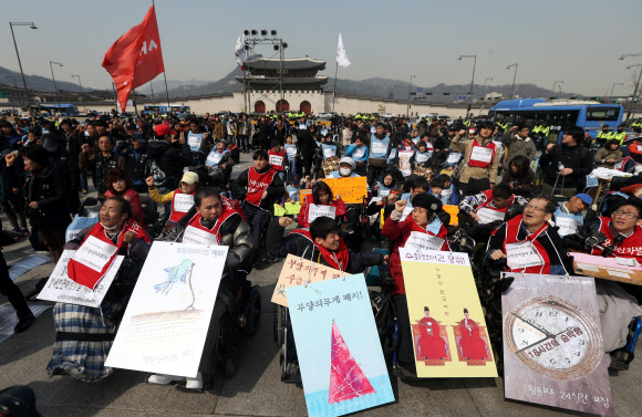 26일 오후 서울 광화문광장에서 열린 제9회 전국장애인대회에서 참석자들이 팻말을 든 채 구호를 외치고 있다. 연합뉴스