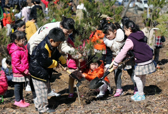 29일 오전 서울 중계동 불암산에서 어린이들이 산철쭉과 백합나무 등을 심고 있다. 노원구는 식목일을 앞두고 ‘한 가정에 하나의 식물심기’ 일환으로 이날 행사를 실시했다. 연합뉴스