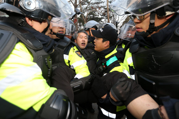 서울 중구청이 4일 새벽 덕수궁 대한문 앞에서 농성 중이던 쌍용차 해고노동자들의 천막을 기습 철거한 가운데 한 범대위 관계자가 철거에 저항하다 경찰에 연행되고 있다. 연합뉴스