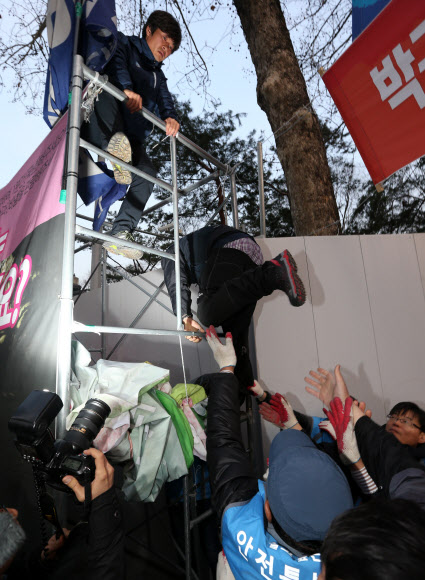 서울 중구청이 4일 새벽 덕수궁 대한문 앞에서 농성 중이던 쌍용차 해고노동자들의 천막을 기습 철거한 가운데 범대위 관계자들이 철거에 저항하며 구조물로 올라가고 있다. 연합뉴스