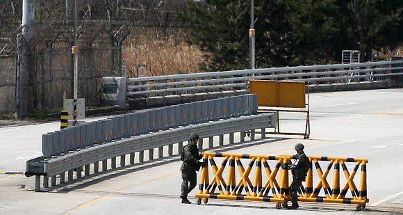 개성공단 운영이 잠정 중단된 가운데 9일 경기도 파주시 경의선 남북출입사무소에서 육군 장병이 귀환 차량을 위해 바리케이드를 옮기고 있다.  연합뉴스