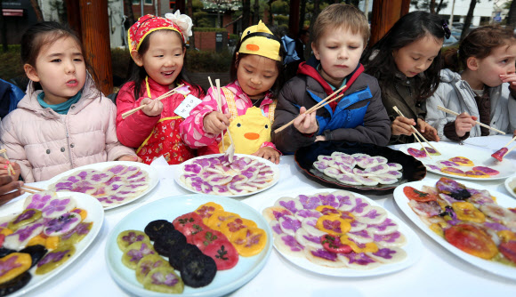 제비가 날아들면 들로 나와 꽃놀이를 즐기며 화전을 부쳐 먹었다는 삼짇날을 맞아 12일 서울 서초구 서래마을에서 열린 화전만들기 행사에서 지역 어린이집 아동들과 프랑스학교 학생들이 진달래꽃으로 만든 화전을 시식하고 있다.  