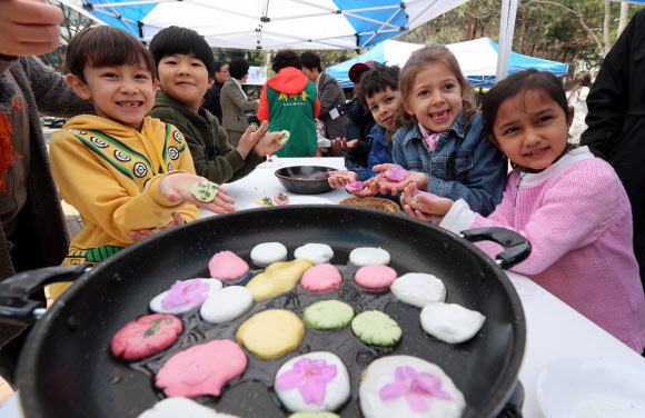 제비가 날아들면 들로 나와 꽃놀이를 즐기며 화전을 부쳐 먹었다는 삼짇날을 맞아 12일 서울 서초구 서래마을에서 열린 화전만들기 행사에서 지역 어린이집 아동들과 프랑스학교 학생들이 진달래꽃을 이용한 화전만들기 체험을 하고 있다.  
