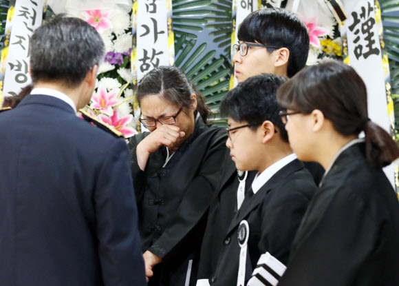 16일 인천시 강화군 강화장례식장에 마련된 고 정옥성 경감의 빈소에서 유족들이 조문객들의 위로에 눈물을 흘리고 있다. 정 경감은 지난달 1일 오후 11시 25분께 강화군 내가면 외포리 선착장에서 자살하려고 물에 뛰어든 김모(45)씨를 구하려 바다에 몸을 던졌다가 실종됐다.  연합뉴스