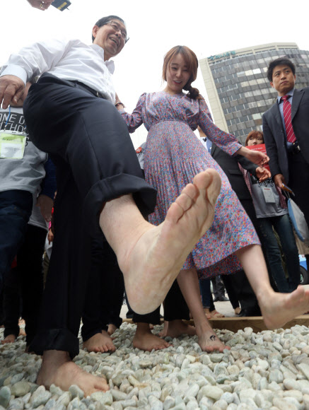 박원순 서울시장이 16일 오후 서울광장에서 열린 ‘신발 없는 하루’ 캠페인에서 맨발로 걷고 있다. ‘신발 없는 하루’는 신발을 하루 동안 벗고 일상을 보내는 날로 신발이 어린이들에게 줄 수 있는 영향력을 알리고, 고객이 신발 한 켤레를 구매할 때마다 맨발의 어린이에게 신발 한 켤레를 전달하는 캠페인이다.  연합뉴스