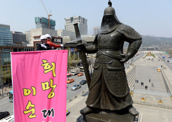 18일 오후 서울 세종로 이순신 장군 동상 앞에서 열린 ‘이순신 장군 동상 친수식’에서 최창식 중구청장(왼쪽)과 복기왕 아산시장이 동상을 세척하고 있다. 연합뉴스