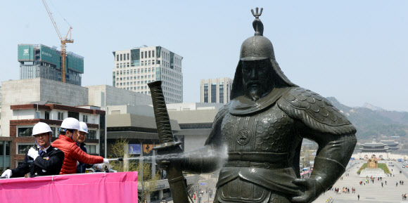 18일 오후 서울 세종로 이순신 장군 동상 앞에서 열린 ‘이순신 장군 동상 친수식’에서 최창식 중구청장(왼쪽)과 복기왕 아산시장이 동상을 세척하고 있다.