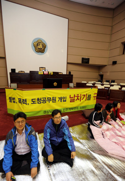 진주의료원 해산 조례안 상정을 앞둔 18일 야당 도의원들이 본회의장 앞에서 시위를 벌이고 있다. 연합뉴스