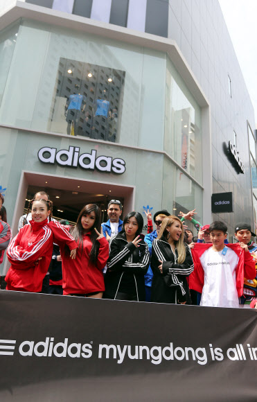 19일 오전 서울 명동 아디다스 플래그십 스토어 리뉴얼 오픈을 기념해 매장을 방문한 가수 2NE1 맴버들이 매장 앞에서 플래시몹 이벤트를 펼친 비보이들과 함께 포즈를 취하고 있다. 연합뉴스