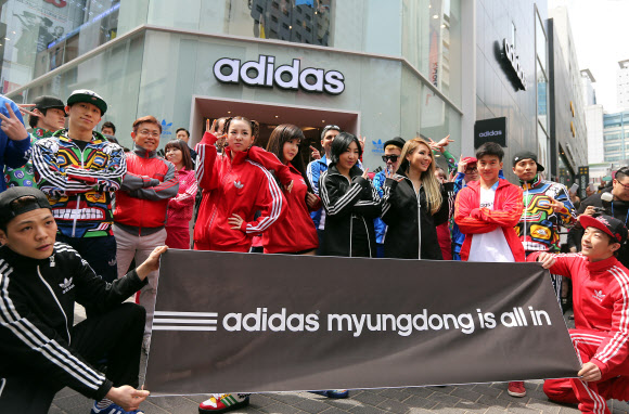 19일 오전 서울 명동 아디다스 플래그십 스토어 리뉴얼 오픈을 기념해 매장을 방문한 가수 2NE1 맴버들이 매장 앞에서 플래시몹 이벤트를 펼친 비보이들과 함께 포즈를 취하고 있다. 연합뉴스