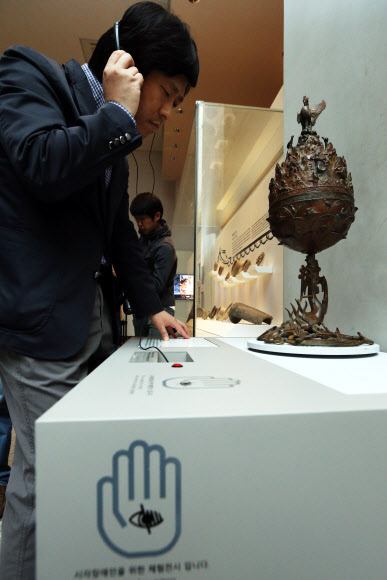 제33회 장애인의 날을 하루 앞둔 19일 오전 서울 국립중앙박물관 내에 조성된 시각장애인을 위한 전시공간에서 한 시각장애인이 백제금동대향로에 대한 점자해설을 읽고 있다. 연합뉴스