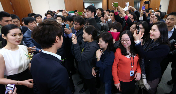 23일 오전 서울 종로구 수송동 국세청 회의실에서 열린 ‘2013 국세청 홍보대사 위촉식’에서 위촉식을 마친 후 직원들이 홍보대사로 위촉된 배우 한가인과 엄태웅을 휴대폰 카메라로 찍고 있다. 연합뉴스
