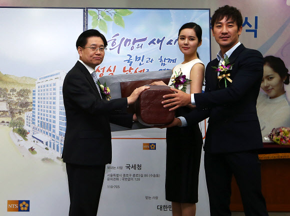 23일 오전 서울 종로구 수송동 국세청 회의실에서 열린 ‘2013 국세청 홍보대사 위촉식’에서 김덕중 청장(왼쪽부터), 배우 한가인, 엄태웅이 성십납세 퍼포먼스를 펼치고 있다. 연합뉴스