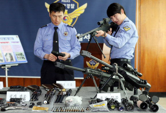 인천 해양경찰서는 해외에서 불법 총기를 밀반입해 국내에 유통한 혐의(총포도검화약류 등 단속법위반)로 A(29)씨 등 4명을 검거했다고 24일 밝혔다. 이들은 지난해 10월부터 최근까지 중국, 홍콩 등 해외에서 밀반입한 공기소총, 모의총기 등 불법 총기류 31점을 인터넷 쇼핑몰에 판매한 혐의를 받고 있다. 사진은 이날 경찰이 압수한 불법 총기를 살펴보는 모습.  연합뉴스