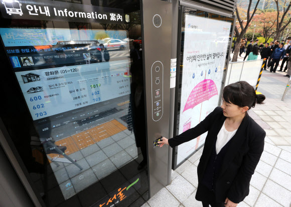 서울시가 내년 3월까지 가로변 버스정류소를 최첨단 시설을 갖춘 정류소로 개선하기로 한 가운데 24일 서울시 관계자가 시범운영 중인 광화문 정류소에서버스카드 충전을 하고 있다. 연합뉴스