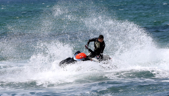낮 최고기온이 영상 22도까지 올라간 24일 강원 강릉시 안목 해변 앞바다에서 제트스키가 거대한 물보라를 일으키며 봄바다를 누비고 있다.  연합뉴스