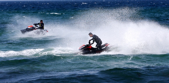 낮 최고기온이 영상 22도까지 올라간 24일 강원 강릉시 안목 해변 앞바다에서 제트스키가 거대한 물보라를 일으키며 봄바다를 누비고 있다.  연합뉴스