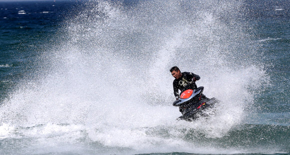 낮 최고기온이 영상 22도까지 올라간 24일 강원 강릉시 안목 해변 앞바다에서 제트스키가 거대한 물보라를 일으키며 봄바다를 누비고 있다. 연합뉴스 