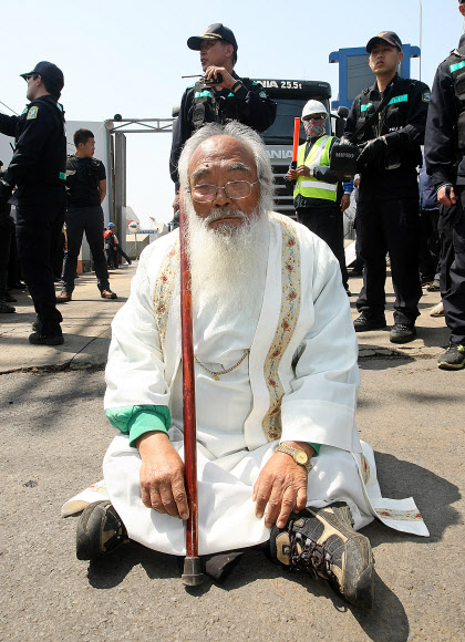25일 오전 제주해군기지(민군복합형 관광미항) 공사장 앞에서 ‘제주군사기지 저지와 평화의 섬 실현을 위한 범도민대책위원회’의 기자회견이 열린 가운데 문정현 신부가 공사중단을 요구하며 해군기지 공사장 앞을 가로막고 있다.  연합뉴스
