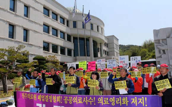 진주의료원 해산 조례안 처리방안을 논의할 경남도의회 긴급 임시회가 열리는 25일 도의회 앞에서 보건의료노조원들이  폐업 결정 철회 등을 요구하며 시위를 벌이고 있다.노조원들은 지난 18일과 달리 등원하는 새누리당 의원들을 저지하지 않고 도의회 결정을 지켜보기로 했다. 연합뉴스