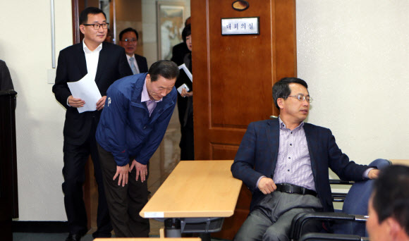 김오영 경남도의회 의장(파란색 점퍼차림)과 강석주 도의회 새누리당 원내대표가 25일 오후 경남도의회 대회의실에서 열리는 의총에 앞서 허리를 굽혀 인사하지만 의원들이 외면하고 있다.의원들은 진주의료원 해산 조례안 처리에 내부 입장을 조율하기 위해 문을 잠그고 비공개로 회의를 진행했다. 연합뉴스