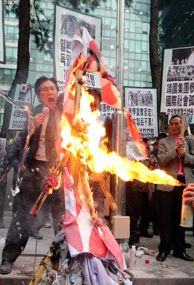 25일 오후 서울 종로구 중학동 일본대사관 앞에서 대한어버이연합과 보수국민연합 회원들이 일본 역사왜곡과 신사참배 규탄 기자회견을 가진 뒤 아베 총리 이름을 붙인 인형에 불을 지르고 있다.  연합뉴스