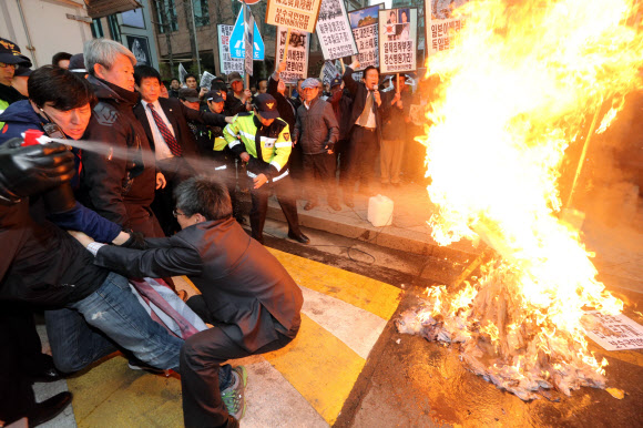 25일 오후 서울 종로구 중학동 일본대사관 앞에서 대한어버이연합과 보수국민연합 회원들이 일본 역사왜곡과 신사참배 규탄 기자회견을 가진 뒤 아베 총리 이름을 붙인 인형에 불을 지르고 있다.  연합뉴스