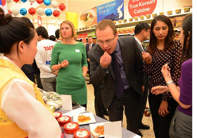지난해 영국 런던 뉴몰든 테스코 매장에서 홈플러스가 공동 개최한 ‘대중소 동반성장을 위한 한국식품전’에서 영국인들이 비빔밥 등을 시식하고 있다. 홈플러스 제공