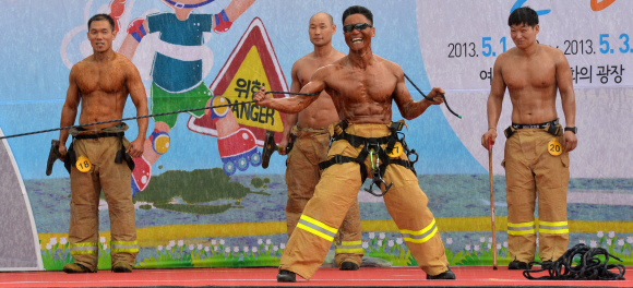 2일 서울 여의도공원 문화광장에서 열린 서울시 최강 몸짱 소방관 선발대회에 참가한 소방관들이 구조장비를 들고 근육을 뽐내고 있다.  