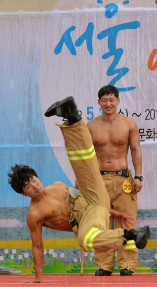2일 서울 여의도공원 문화광장에서 열린 서울시 최강 몸짱 소방관 선발대회에 참가한 한 소방관이 브레이크 댄스를 추며 근육을 뽐내고 있다.  