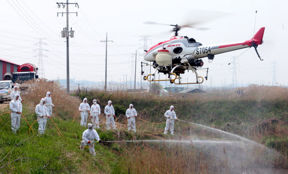 3일 경기도 화성시 남양만 철새도래지와 인근 양계농장에서 NH농협 직원들과 관계자들이 각종 장비를 이용한 조류인플루엔자(AI) 방역 소독 활동을 시연하고 있다.  연합뉴스