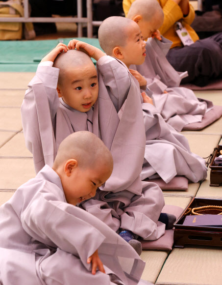 3일 종로구 조계사에서 열린 불기 2557년 부처님 오신날 맞이 ‘동자승 단기출가 삭발 및 수계식’에서 동자승들이 삭발을 한 뒤 머리를 만지고  있다.  연합뉴스