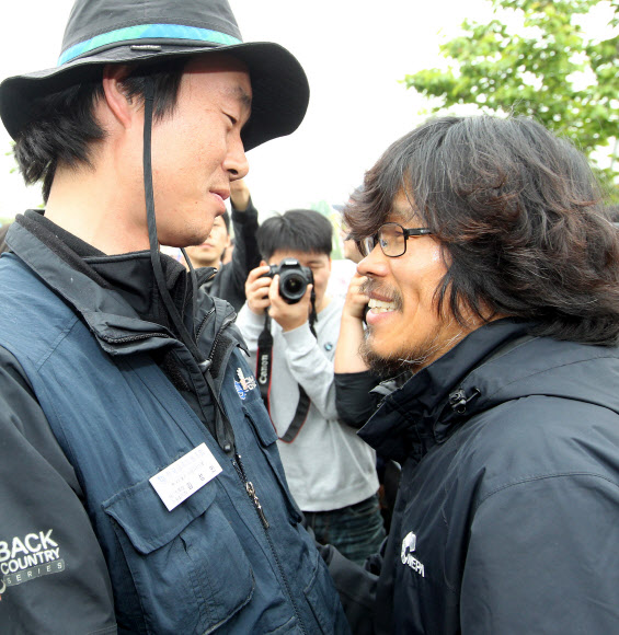 9일 오전 지난해 11월 20일부터 쌍용자동차 정리해고에 관한 국정조사와 해고자 복직 등을 요구하며 쌍용차 평택공장 인근 송전탑에 올라 농성을 벌여온 금속노조 쌍용차지부 한상균 전 지부장(오른쪽)이 농성을 풀고 송전탑에서 내려온 뒤 동료와 인사를 나누고 있다. 연합뉴스