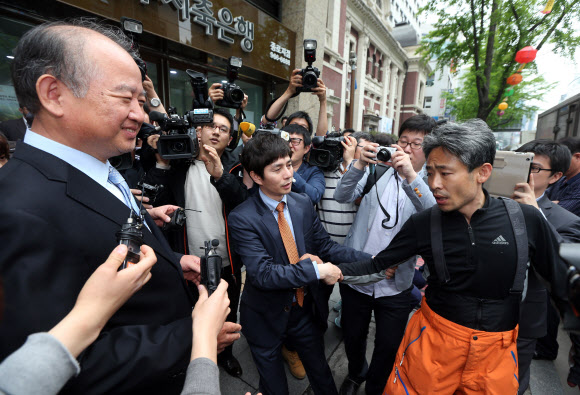 남양유업 김웅 대표이사(왼쪽)가 9일 오후 서울 중구 남양유업 본사 앞에서 기자회견을 하기 위해 대기 중인 남양유업대리점협의회 회원을 찾아가 사과인사를 시도하고 있다. 한 남양유업 직원이 거절하는 대리점주의 팔을 잡아당기며 악수를 권하고 있다. 연합뉴스