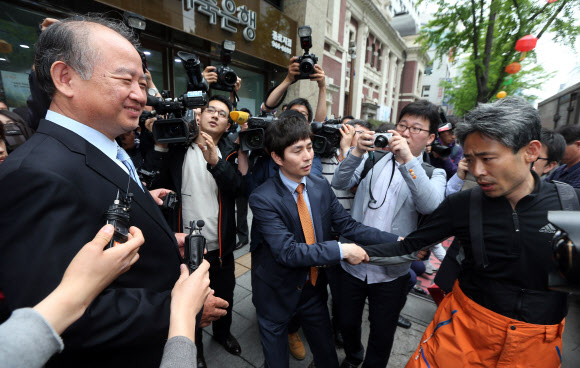 남양유업 김웅 대표이사(왼쪽)가 9일 오후 서울 중구 남양유업 본사 앞에서 기자회견을 하기 위해 대기 중인 남양유업대리점협의회 회원을 찾아가 사과인사를 시도하고 있다. 연합뉴스