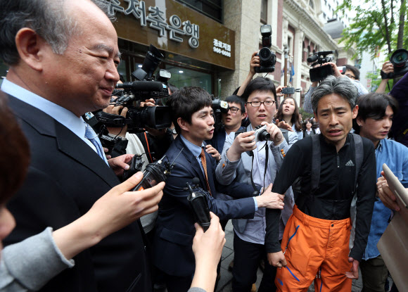 남양유업 김웅 대표이사(왼쪽)가 9일 오후 서울 중구 남양유업 본사 앞에서 기자회견을 하기 위해 대기 중인 남양유업대리점협의회 회원을 찾아가 사과인사를 시도하고 있다.  한 남양유업 직원이 거절하는 대리점주의 팔을 잡아당기며 악수를 권하고 있다. 연합뉴스
