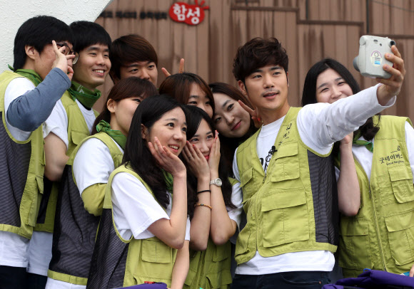 10일 오전 서울 종로구 성균관대학교 금잔디광장에서 열린 ‘굿네이버스 아프리카 희망학교 책가방 보내기’ 행사에서 배우 김강우 씨가 자원봉사자들과 함께 아프리카로 보낼 사진을 찍고 있다. 연합뉴스