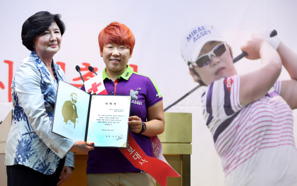 10일 서울 남산 대한적십자사 본사에서 홍보대사에 임명된 골프선수 신지애가 유중근 총재에게 서약서를 전달하고 있다.   연합뉴스