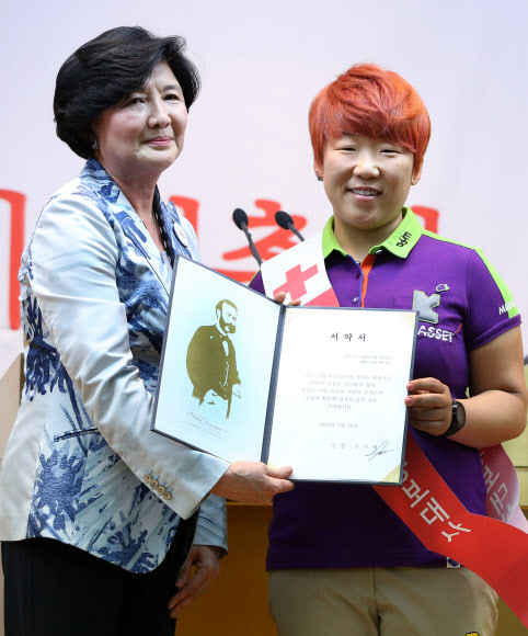 10일 서울 남산 대한적십자사 본사에서 홍보대사에 임명된 골프선수 신지애가 유중근 총재에게 서약서를 전달하고 있다.  연합뉴스