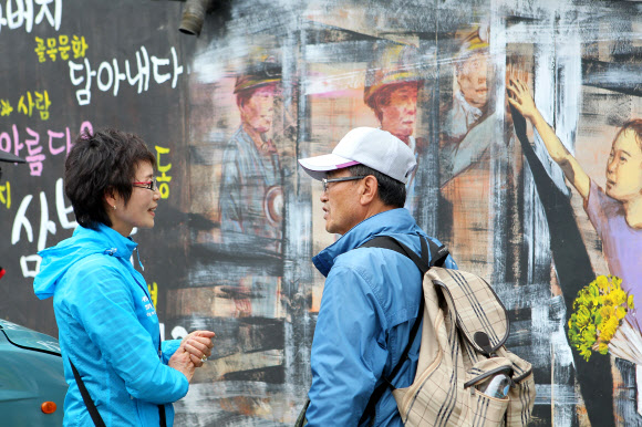 옛 탄광촌 모습을 간직한 태백시 삼방동을 관광객들이 둘러보고 있다. 시곗바늘이 석탄산업이 한창이던 1970년대에서 멈춘 삼방동의 골목길에 벽화가 그려지고 백두대간 협곡열차가 운행하면서 관광객 발길이 이어지고 있다.  연합뉴스