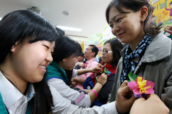 스승의 날을 하루 앞둔 14일 오전 경기도 수원시 팔달구 장안로 영복여자중학교에서 영복여중 청소년적십자단원들이 감사의 마음을 담아 선생님들의 가슴에 꽃을 달아드리고 있다.  연합뉴스