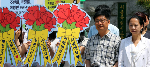 15일 오전 서울 종로구 서울특별시교육청 앞에서 열린 ‘민주ㆍ양심교사 조연희,박정훈,이형빈 선생님 복직촉구’ 기자회견에서 조연희(맨 오른쪽)씨와 박정훈 씨가 굳은 표정으로 기자회견에 참여하고 있다.  연합뉴스