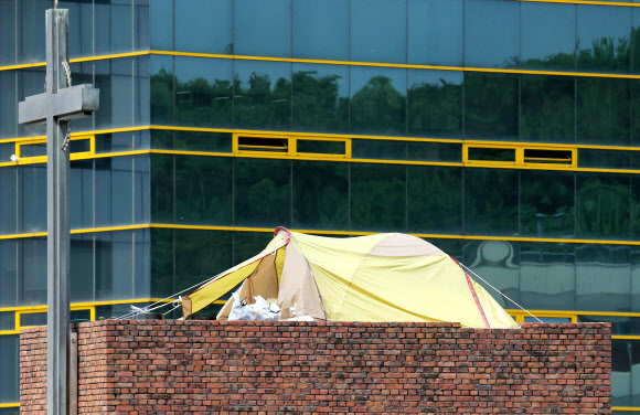 재능교육 노조의 여성 조합원 2명이 서울 혜화동 성당 종탑에서 벌이고 있는 고공농성이 오는 16일로 100일째를 맞는다. 이날 99일째 이어지고 있는 고공농성 현장 뒤로 재능교육 건물이 보인다.  연합뉴스