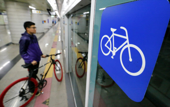 지하철 5∼8호선을 운영하는 서울도시철도공사가 자전거 승차 관련 내용(자전거를 끌고 승차하는 것은 법정공휴일에만, 열차 맨 앞칸과 뒤칸에만 가능)을  명시한 ‘지하철 이용약관’을 각 역사 고객안내센터와 승강장 등에 부착했다.19일  서울시내 한 5호선에서 시민이 자전거를 가지고 이동하고 있다. 연합뉴스