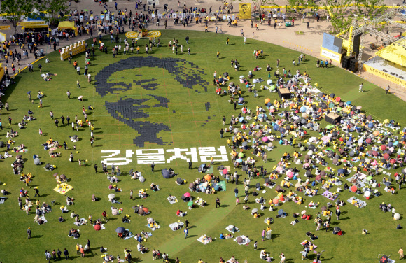 노무현 4주기 추모문화제가 열린 19일 오후 서울광장에서 시민이 노무현 전 대통령의 뜻을 기리기 위해 픽셀화를 만드는 퍼포먼스를 하고 있다.  연합뉴스