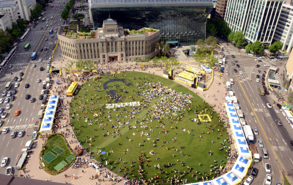 노무현 4주기 추모문화제가 열린 19일 오후 서울광장에서 시민이 노무현 전 대통령의 뜻을 기리기 위해 픽셀화를 만드는 퍼포먼스를 하고 있다.  연합뉴스