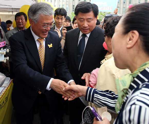 문재인 민주당 의원(오른쪽)이 19일 오후 노무현재단 주최로 서울광장에서 열린 ‘노무현 대통령 서거 4주기 서울광장 추모문화제’에 참석해 지지자와 악수하고 있다. 연합뉴스