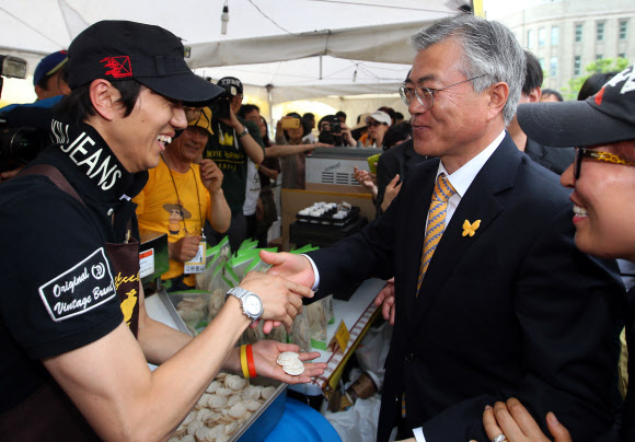 문재인 민주당 의원(오른쪽)이 19일 오후 노무현재단 주최로 서울광장에서 열린 ‘노무현 대통령 서거 4주기 서울광장 추모문화제’에 참석해 지지자와 악수하고 있다. 연합뉴스