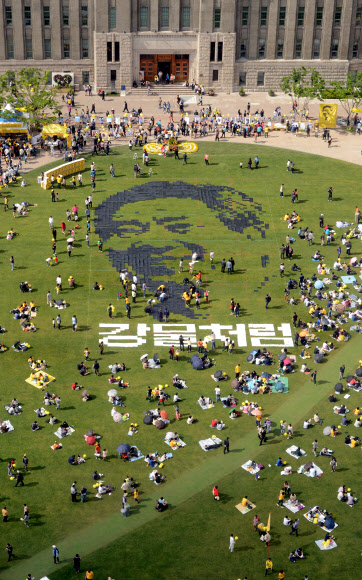 노무현 4주기 추모문화제가 열린 19일 오후 서울광장에서 시민이 노무현 전 대통령의 뜻을 기리기 위해 픽셀화를 만드는 퍼포먼스를 하고 있다.  연합뉴스