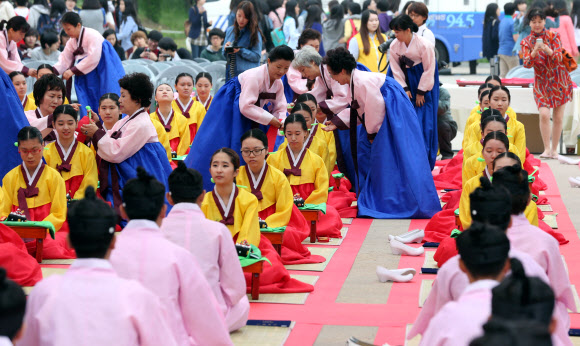 20일 서울 남산골 한옥마을에서 열린 전통 성년례(成年禮)에서 올해로 20세가 된 1993년생대학생 등이 족두리를 착용하기에 앞서 비녀를 꼽고 있다.